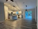 Open-concept living area featuring new floors, updated kitchen, and sliding glass doors to outside at 4424 Sw Viola Ct, Dunnellon, FL 34431