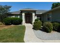 Inviting front entry with decorative landscaping and a well-lit pathway leading to the front door at 4677 Nw 46Th Ave, Ocala, FL 34482