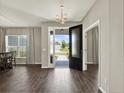 Elegant foyer with hardwood floors, a modern chandelier, and a view of the front yard through the glass door at 4806 Nw 8Th Ter, Ocala, FL 34475