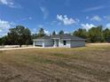 A beautiful single-story home with a gray exterior and a well-maintained lawn at 4928 Sw Evergreen Ct, Dunnellon, FL 34431