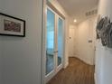 Hallway featuring glass doors, modern light fixtures, and wood-look tile flooring at 5785 Sw 87Th Court Rd, Ocala, FL 34481