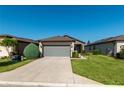 Charming home featuring a stone facade, two-car garage, landscaped yard, and a sidewalk leading to the front door at 6132 Sw 94Th Ter, Ocala, FL 34481