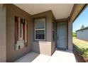 Inviting front porch with a gray front door, neutral walls, and natural light at 6132 Sw 94Th Ter, Ocala, FL 34481