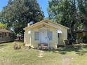 Cottage-style home with a sunny yellow exterior and a well-maintained front lawn at 621 Ne 20Th St, Ocala, FL 34470