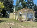 Quaint yellow cottage with white trim, chimney, and established landscaping at 621 Ne 20Th St, Ocala, FL 34470