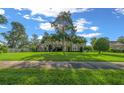 Inviting single-story home featuring a sprawling front yard, mature shade trees, and a concrete sidewalk at 811 Se 49Th Ave, Ocala, FL 34471