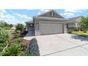 Single story home featuring a wide driveway leading to a two car garage with an arched top window at 8693 Sw 76Th Ln, Ocala, FL 34481