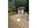 View of the shed with decorative statues and gravel landscaping in a backyard setting at 8951 Sw 202Nd Avenue Rd, Dunnellon, FL 34431