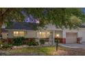 Charming single-story home at dusk featuring a well-kept lawn and an attached garage at 9855 Sw 85Th Terrace Rd # A, Ocala, FL 34481