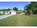 Charming single-story home with an attached two-car garage and a well-manicured lawn at 10668 Sw 85Th Ter, Ocala, FL 34481