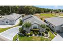 Inviting single-story home with a beautifully landscaped front yard and a long driveway leading to the garage at 17505 Se 100Th Ct, Summerfield, FL 34491