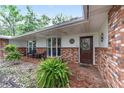 Inviting front porch with brick accents, wicker seating, and lush ferns providing a welcoming outdoor space at 1781 Se 85Th Street Rd, Ocala, FL 34480
