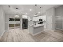 Modern kitchen features white cabinets, a center island with black fixtures, and stainless steel appliances at 20751 Sw Cardinal Ave, Dunnellon, FL 34431