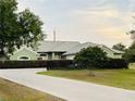 Charming single-story home with a well-manicured lawn, concrete driveway, and lush green landscaping at 2910 Ne 24Th Pl, Ocala, FL 34470