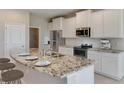 Modern kitchen featuring stainless steel appliances, granite counters, and a large island at 3076 Canopy Oak Blvd, Wildwood, FL 34785
