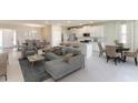 Open-concept living space with kitchen, living room, and dining area with lots of natural light at 3076 Canopy Oak Blvd, Wildwood, FL 34785