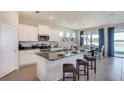Open-concept kitchen with stainless steel appliances, granite countertops, and a breakfast bar at 3080 Canopy Oak Blvd, Wildwood, FL 34785