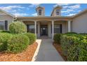 Inviting covered entryway with decorative columns and lush landscaping at 4735 Se 35Th St, Ocala, FL 34480