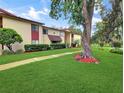 Multi-Gathering unit with mature trees, vibrant green lawn, and sidewalk leading to the entrance at 700 Midway Dr # B, Ocala, FL 34472