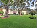 Exterior shot showcasing the manicured lawn and mature trees surrounding the multi-Gathering unit at 700 Midway Dr # B, Ocala, FL 34472