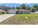 Charming single-story home with a well-manicured lawn, a two-car garage, and mature landscaping at 72 Dogwood Loop, Ocala, FL 34472