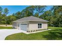 Detached two-car garage with paved driveway and tidy landscaping at 8498 Sw 129Th Terrace Rd, Dunnellon, FL 34432