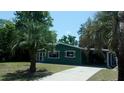 Green home featuring palm trees, carport and a sunroom at 9880 Sw 101St Pl, Ocala, FL 34481