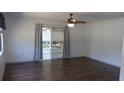 Bright living room with wood flooring, a ceiling fan, and sliding doors to a lanai at 9880 Sw 101St Pl, Ocala, FL 34481