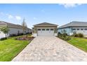 Charming single-story home featuring a paved driveway and a 2-car garage with a lush green lawn at 10347 Sw 99Th Ln, Ocala, FL 34481