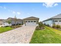 Charming single-story home featuring a paved driveway and a 2-car garage with a lush green lawn at 10347 Sw 99Th Ln, Ocala, FL 34481