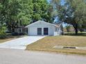 Charming single-story house with attached two-car garage and a concrete driveway on a sunny day at 11025 Sw 64Th Ave, Ocala, FL 34476