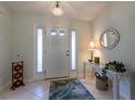 Inviting foyer with neutral tile flooring, decorative mirror, and elegant chandelier at 15691 Sw 11Th Court Rd, Ocala, FL 34473