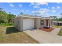 Exterior view of a modern home with a white garage door, neutral siding, and tidy landscaping at 17147 Sw 42Nd Ct, Ocala, FL 34473