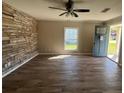 Living room featuring wood floors, stone accent wall, and an exterior door at 21135 Sw Honeysuckle St, Dunnellon, FL 34431