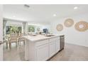 Open-concept kitchen featuring island seating, stainless steel appliances and an adjacent dining area at 2656 Sw 175Th Loop, Ocala, FL 34473