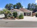 Charming single-story home featuring mature landscaping, a spacious driveway and inviting front porch seating at 3154 Merrit Ln, The Villages, FL 32163