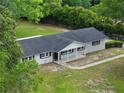 An aerial view of a single story house with a spacious yard, sidewalk and lush trees at 4430 Se 47Th Pl, Ocala, FL 34480