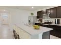 Modern kitchen with dark cabinetry, stainless steel appliances, a spacious island, and a stylish breakfast bar at 4698 Sw 88Th Ln, Ocala, FL 34476