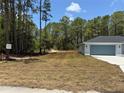 View of the home from across the street showing expansive yard and view of trees behind property at 6178 Sw 207Th Ct, Dunnellon, FL 34431