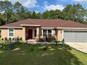 Inviting single-story home with a neat front yard and cozy, covered entrance at 7488 Sw 204Th Ave, Dunnellon, FL 34431