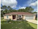 Charming single-story home featuring a well-maintained lawn and a cozy front entrance at 7488 Sw 204Th Ave, Dunnellon, FL 34431