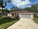 Attractive single-story home with a well-manicured lawn and a convenient two-car garage at 7488 Sw 204Th Ave, Dunnellon, FL 34431