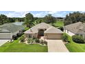 Inviting single-story home offers a well-manicured lawn with lake and golf course views at 8545 Se 168Th Kittredge Loop, The Villages, FL 32162