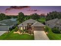 Beautiful single-story home boasts a well-manicured lawn with lake and golf course views in a lovely neighborhood at 8545 Se 168Th Kittredge Loop, The Villages, FL 32162