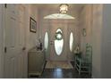Inviting foyer with tile flooring, decorative door with sidelights, and neutral decor at 9129 Sw 193Rd Cir, Dunnellon, FL 34432