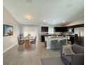 Open floor plan featuring kitchen with central island, stainless appliances, and adjacent dining area at 9983 Sw 188Th Cir, Dunnellon, FL 34432