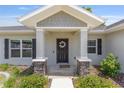 Inviting front entrance featuring stone accents, a decorative wreath, and a welcoming 'hello' mat at 10081 Se 68Th Ct, Belleview, FL 34420