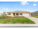 Inviting single-story home showcasing a lush lawn, a paver driveway, and a convenient two-car garage at 10556 Sw 96Th Lane Rd, Ocala, FL 34481