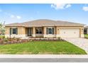 Charming single-story home featuring a manicured lawn, complemented by a paver driveway and welcoming two-car garage at 10556 Sw 96Th Lane Rd, Ocala, FL 34481