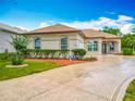 Charming home featuring a circle driveway with a decorative star inlay and well manicured landscaping at 11945 Se 171St Loop, Summerfield, FL 34491